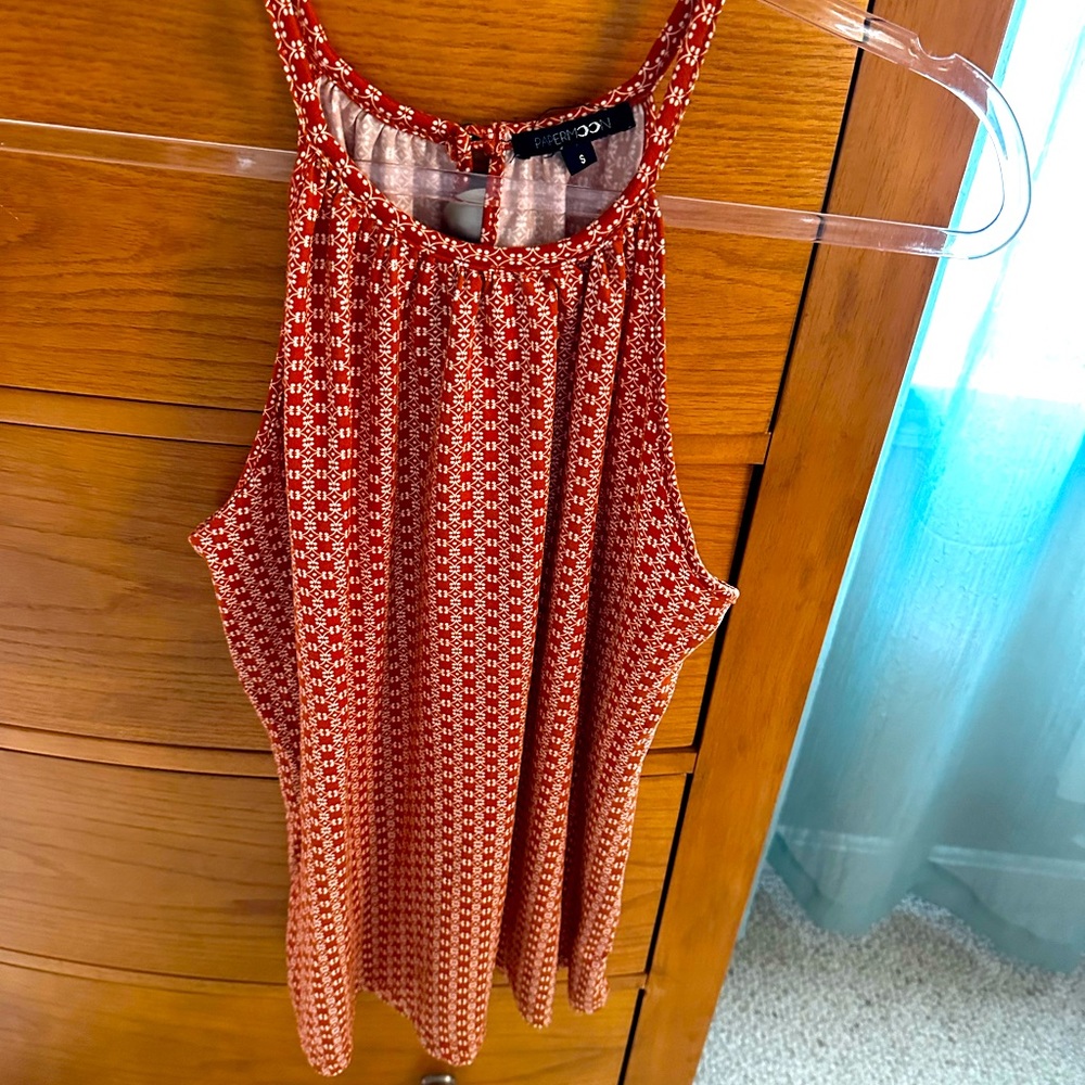 Print tunic, women’s size S, rust and white cotton knit. Button closure on back